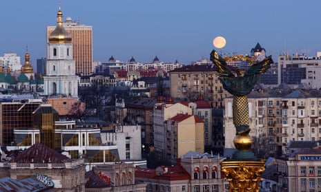 The moon sets over the Independence Monument and buildings in Kyiv, Ukraine