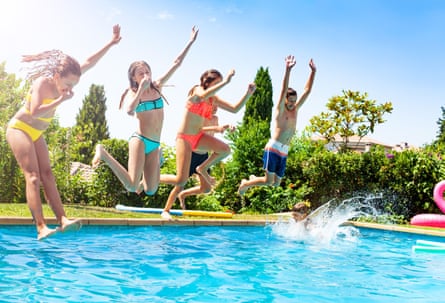 Happy kids in a group of friends jump into water of swimming pool together