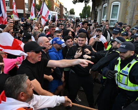 Protesters and police scuffle on a street outside council offices in Epping