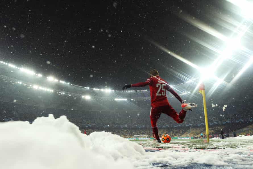 Thomas Müller takes a corner surrounded by snow cleared from the pitch.