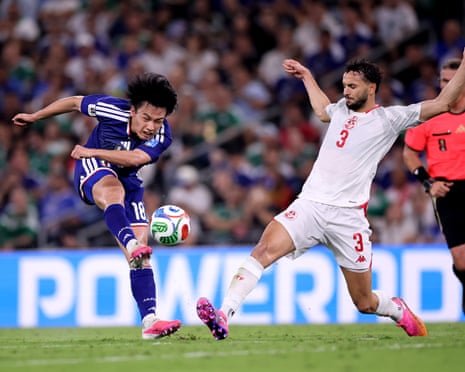 Japan’s Ayase Ueda shoots against Montassar Talbi of Tunisia during their Group F match in Monterrey.