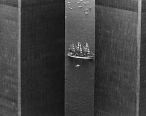 Tall ship USS Constellation with sails up is seen sailing down the river between the towers of the World Trade Center in New York in 1976 in a black and white picture.
