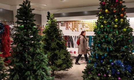 planning to start a business A woman walking past Christmas trees in a John Lewis store