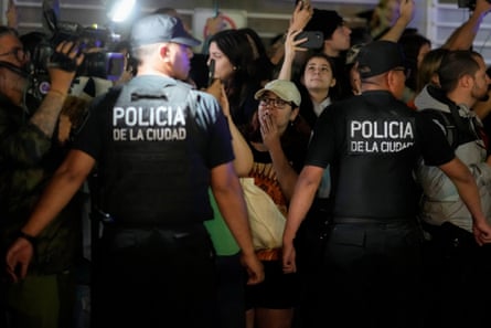 Police restrain fans gathering outside the hotel in Palermo.