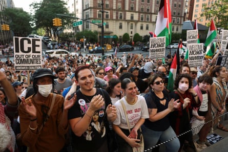 people stand outside, holding signs like 'ice out of our communities' and 'welcome home mahmoud! free palestine! free them all!'