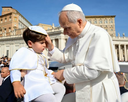 Pope Leo blesses a grumpy-looking child in St Peter’s Square