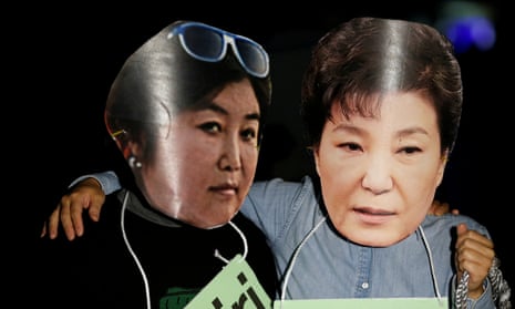 Protesters wearing cut-outs of South Korean president Park Geun-hye and Choi Soon-sil