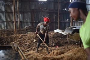 In Kampala, women shovel and sort sawdust (from scrap wood) to make briquettes