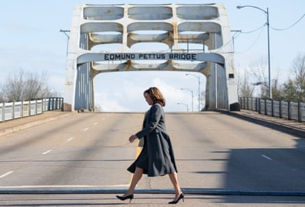 A woman crosses the street of a bridge.