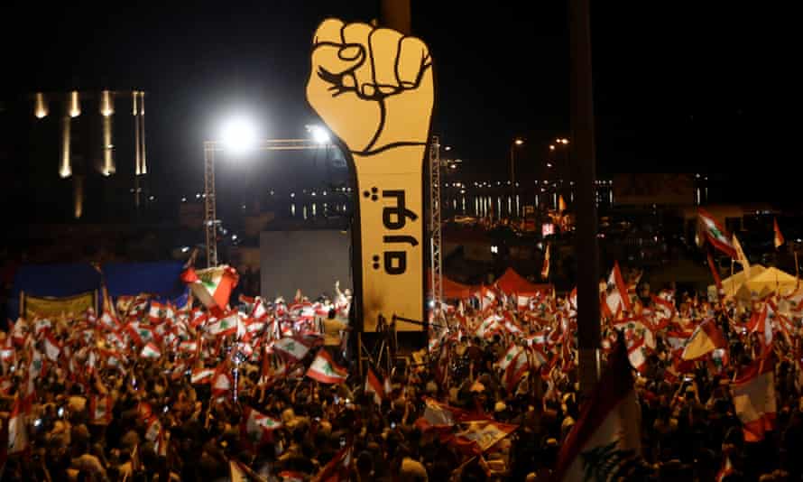 Lebanese demonstrators wave national flags during anti-government protests in November 2019.
