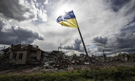 A Ukrainian flag waves in a residential area heavily damaged in the village of Dolyna in Donetsk Oblast,  after the withdrawal of Russian troops .