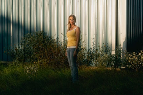 A woman stands near the exterior of a building.