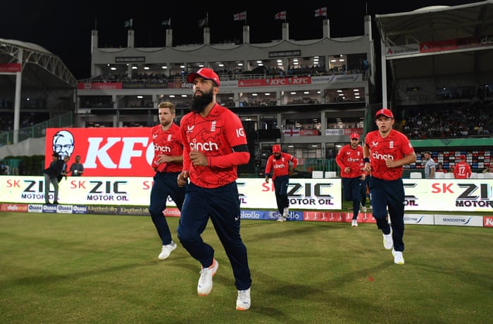 Moeen Ali leads England out.