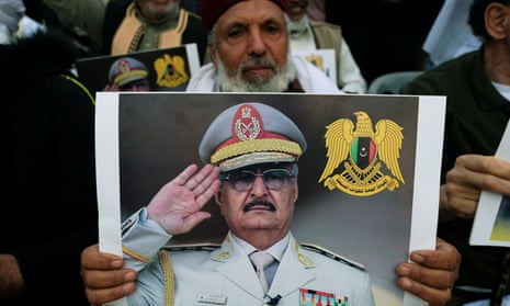 A protester carries a picture of Khalifa Haftar in Benghazi, Libya, April 2019