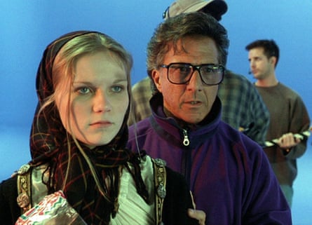 Kirsten Dunst, wearing a headscarf and with smudges of dirt on her face, and Dustin Hoffman with a blue-screen set in the background