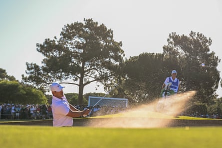 Brooks Koepka plays out of the bunker flicking sand into the air