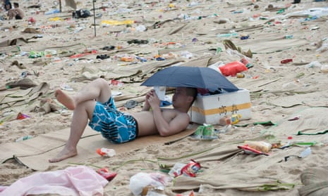 A tourist surrounded by rubbish on a beach in China. The country has struggled to contain environmental pollution during its long economic boom. 