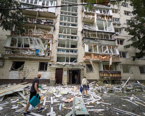 People tread on the rubble outside an apartment block in the Holosiivskyi district damaged by the Russian missile and drone attack, Kyiv, Ukraine.