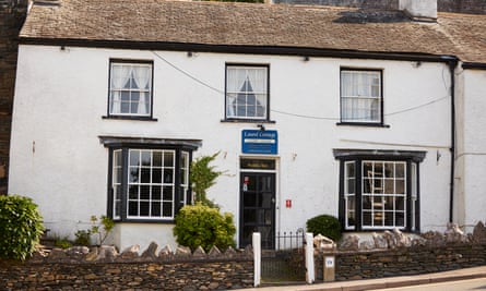 Wide shot of whitewashed house with guesthouse sign
