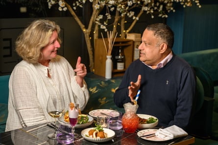 A woman and man facing each other across a restaurant table