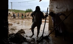 Afghan men shovel mud from a house following flash floods after heavy rains at a village in Baghlan province northern Afghanistan on Saturday