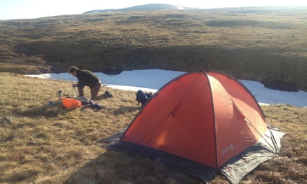 Writer Caroline Eden's husband setting up a tent for wild camping in the Cairngorms, Scotland, UK.