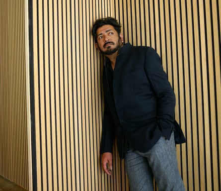 Oncologist Siddhartha Mukherjee, in black jacket and jeans, leaning in a corner, photographed in New York, October 2022