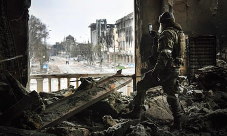 A Russian soldier patrols at the Mariupol drama theatre, which was hit by an airstrike last month.