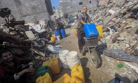 Palestinians collect water amid the rubble in Jabaliya refugee camp in the northern Gaza Strip.