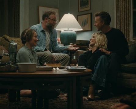 Four adults sit around the front room, chatting animatedly