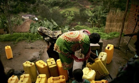 Women fill jugs of water from a tap  in Kaynabayonga, DRC