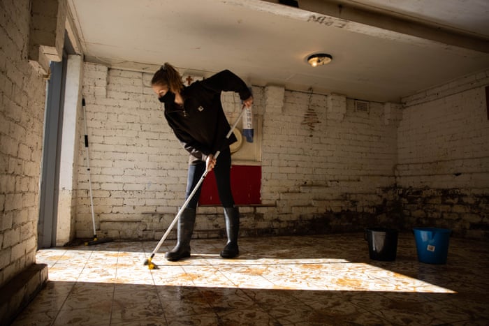Abigail Woods cleans her family’s downstairs basement in the town of Windsor, which was inundated by flood water this week.