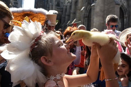 A woman holds a duck at the Easter Parade and Bonnet festival on 5th Avenue, New York City, in April