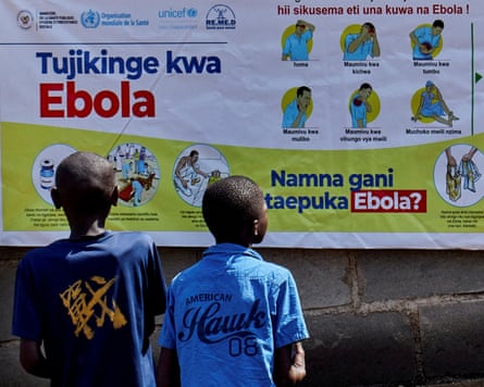 Two young African boys reading an infographic poster on a wall