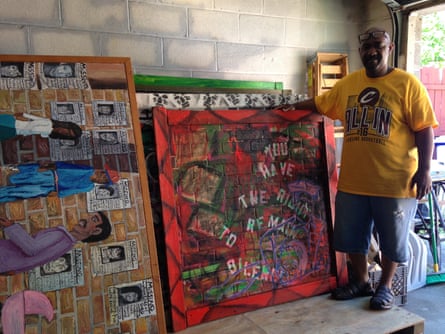 Michelangelo Lovelace with some of his paintings, including one from the Rodney King series.