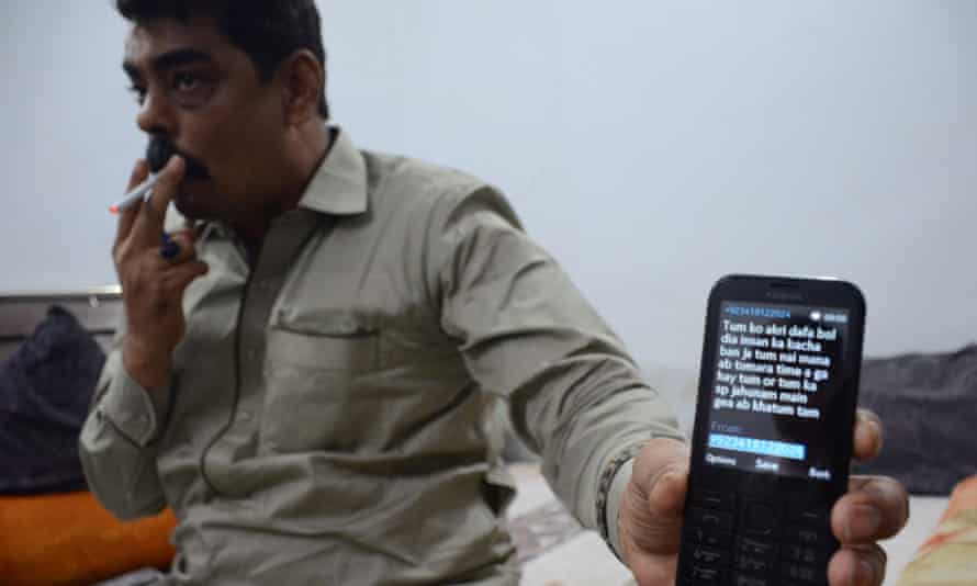 Police officer Shoaib Sheikh – nicknamed Shoaib Shooter – who admits to killing scores of militants, shows a death threat texted to his mobile.
