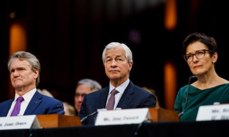 jamie dimon seated at a panel table with a man and a woman either side of him