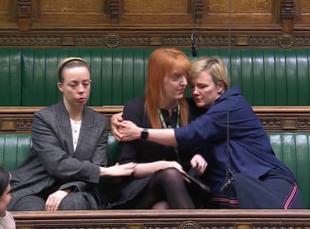 Charlotte Nichols sitting on the House of Commons benches, being hugged by fellow MP Stella Creasy