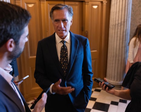 man in suit speaks to reporters in hallway
