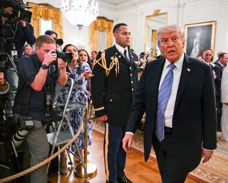 Media photographing Trump as he departs an event in the White House on Monday