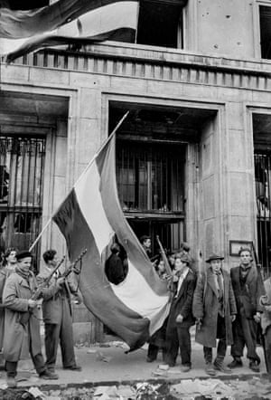 Los jóvenes rebeldes después cortaron el escudo de armas Rakosi Comunista de la bandera húngara