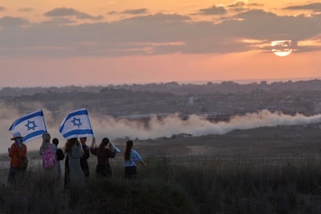 Israeli right-wing activists watch the northern Gaza Strip during a rally calling for the re-establishment of Jewish settlements in the Gaza Strip, near the border in southern Israel on 30 July.
