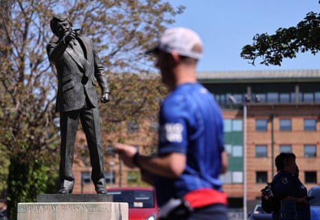 An Ipswich Town fan passes the statue of Sir Bobby Robson outside Portman Road.