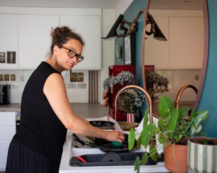 Dale Berning-Sawa washes up frying pans in a kitchen