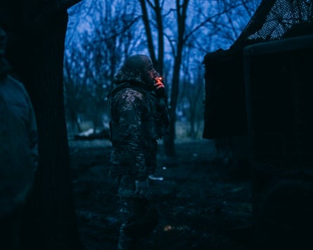 Soldiers stand beside the truck as daylight is beginning to break