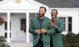 Tiger Woods, right, presents Dustin Johnson with his first green jacket.