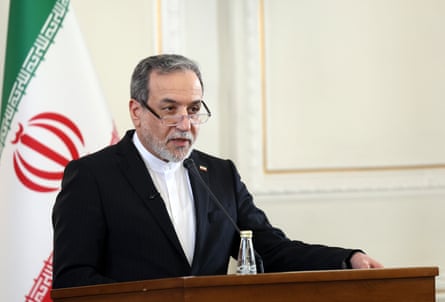 Abbas Araghchi speaking at lectern with Iran flag behind him