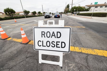 Road Closed sign with police vehicles on empty street.