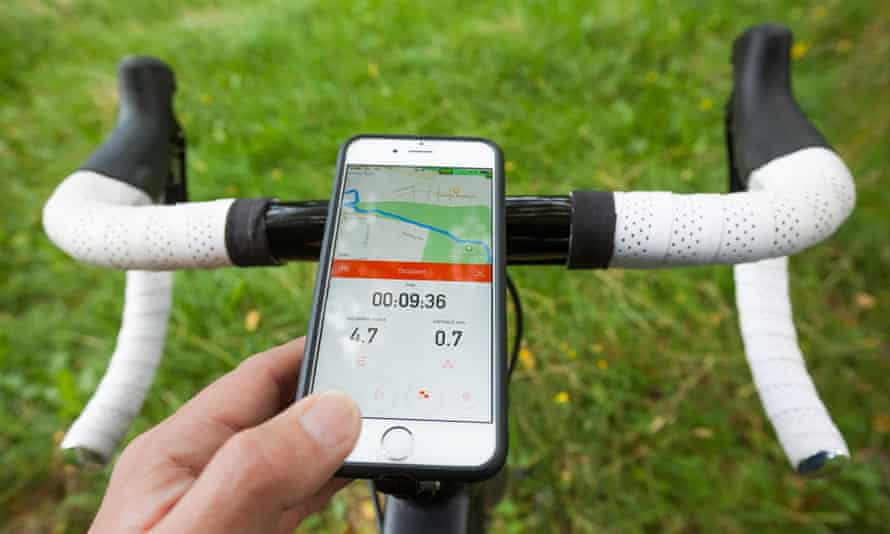 Rider's perspective of a smartphone mounted on the handlebars of a road bike showing a map, elapsed time, distance traveled and a message saying 'paused'