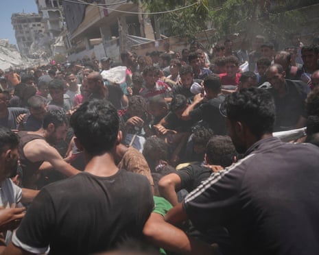 Palestinians struggle to collect humanitarian aid airdropped by parachutes into Gaza City, northern Gaza